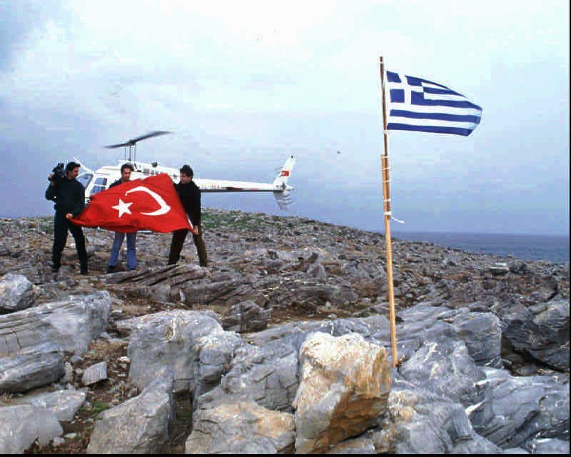 Turkish daily Hurriyet's correspondent Cesur Sert, center, Osman Korkmaz, a cameraman of private TV Channel D, left, and Kemal Suler, a helicopter pilot, on Saturday, Jan.27, 1996 prepare a big Turkish flag to replace the Greek flag placed by Greeks a day before in contested Kardak (Imia) island. Turkey and Greece both claim the tiny deserted piece of land 4.5 miles (7 kms) off the Turkish shore and east of the Greek island Kalimnos. The controversy has resulted in an exchange of protest notes.(AP Photo/Hurriyet, Aykut Firat)